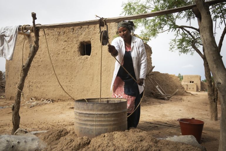 Salimata Dagnogo, 32, Matron of Talo Health Centre, collects dirty water from an open well in the village. Salimata has worked at Talo for eight years and faces big challenges in her role without the