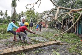 Men remove a fallen electricity pole from a road after Cyclone Amphan made its landfall, in South 24 Parganas district, in the eastern state of West Bengal, India, May 21, 2020. REUTERS/Rupak De Chowd