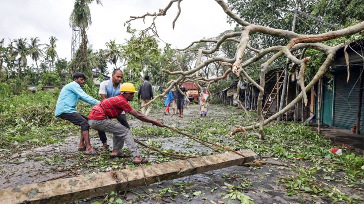 Men remove a fallen electricity pole from a road after Cyclone Amphan made its landfall, in South 24 Parganas district, in the eastern state of West Bengal, India, May 21, 2020. REUTERS/Rupak De Chowd