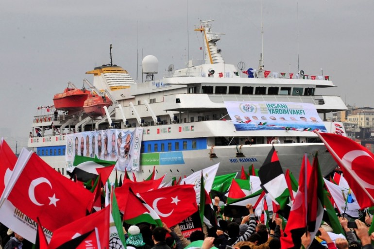 Pro-Palestinian activists wave Turkish and Palestinian flags during the welcoming ceremony for cruise liner Mavi Marmara at the Sarayburnu port of Istanbul