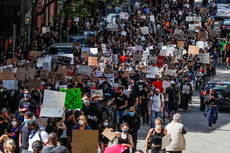 Protesters carry signs at a rally following the death in Minneapolis police custody of George Floyd, in Boston, Massachusetts, U.S., May 31, 2020. REUTERS/Brian Snyder
