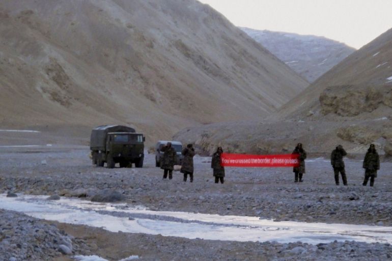 In this May 5, 2013 file photo, Chinese troop hold a banner which reads, "You''ve crossed the border, please go back," in Ladakh, India. Chinese President Xi Jinping is coming to India to meet with Pr