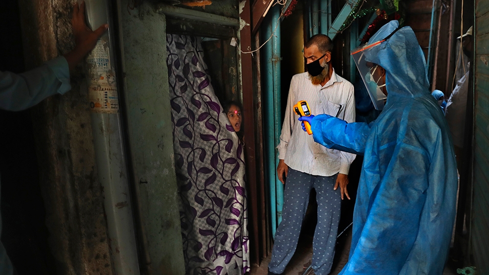 A doctor check the temperature of a girl in Dharavi, one of Asia's largest slums, during lockdown to prevent the spread of the new coronavirus in Mumbai, India, Monday, April 13, 2020. The new coronav