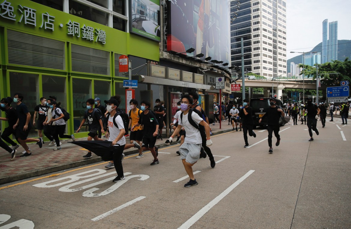 Protesters run as they are chased by police during a protest against Beijing''s national security legislation in Causeway Bay in Hong Kong, Sunday, May 24, 2020. Hong Kong police fired volleys of tear