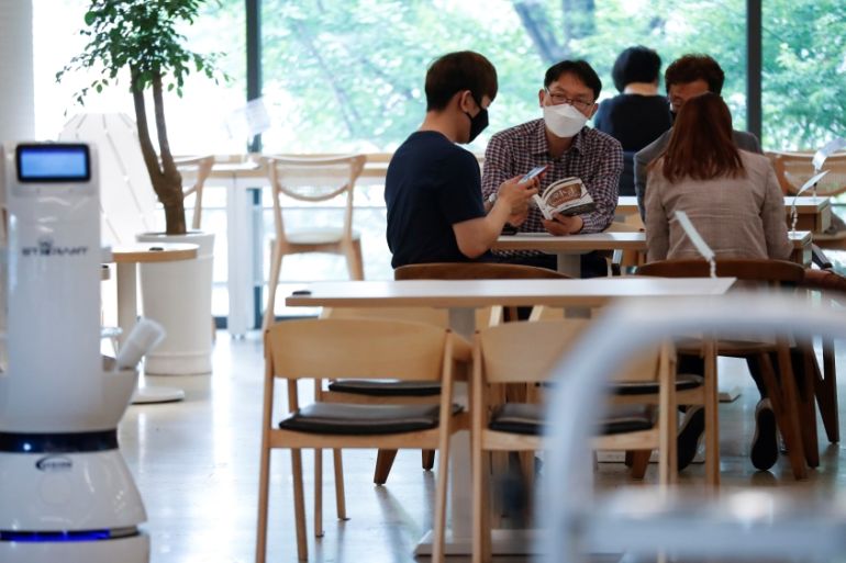 Customers wait at a cafe where a robot that takes orders, makes coffee and brings the drinks straight to customers is being used in Daejeon