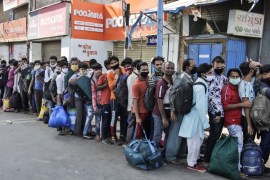 Migrant workers from other states trying to return to their homes stand in queue as they wait for transportation to a train station in Ahmedabad, India, Sunday, May 17, 2020. Tens of thousands of migr
