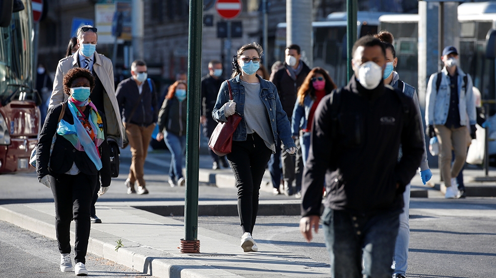 People wearing protective masks walk on a street, as Italy begins a staged end to a nationwide lockdown due to the spread of the coronavirus disease (COVID-19), in Rome, Italy May 4, 2020. REUTERS/Rem