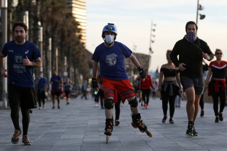 People exercise at the Barceloneta beach during the hours in which individual exercise is allowed outdoors, for the first time since the lockdown was announced, amid the c