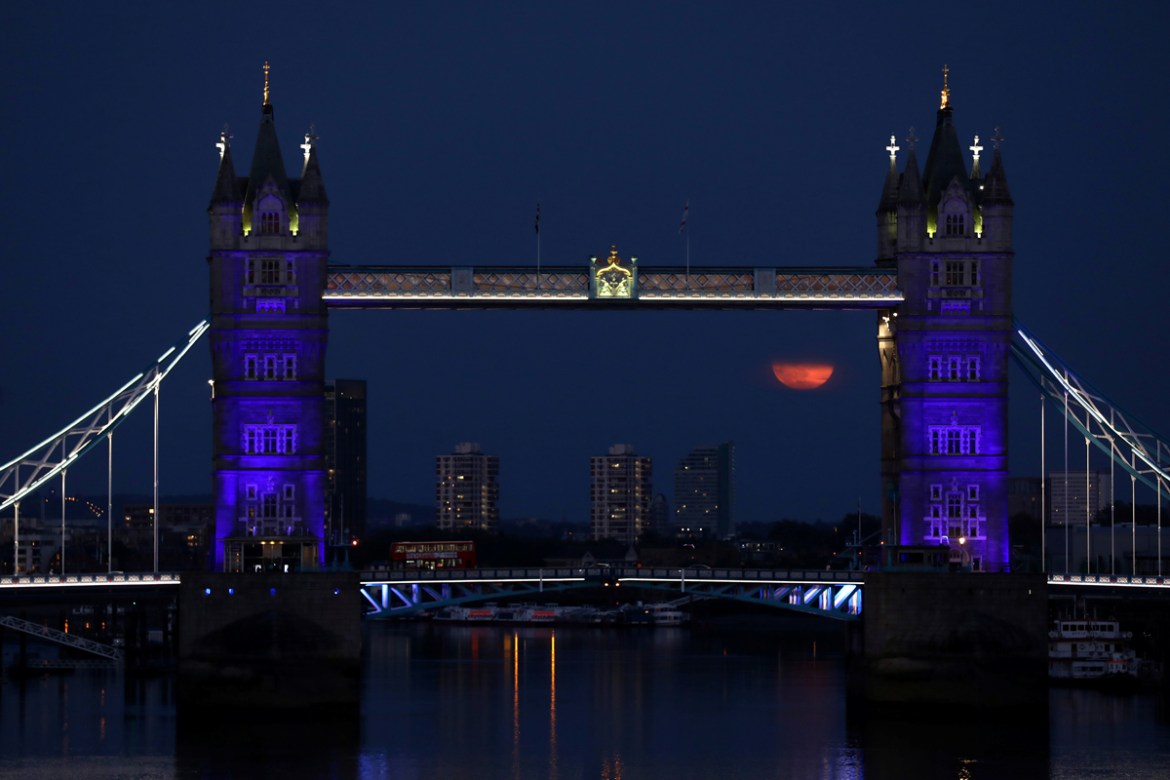 The full moon, also known as the Supermoon or Flower Moon, is seen next to Tower Bridge, London, Britain, May 7, 2020. REUTERS/Simon Dawson