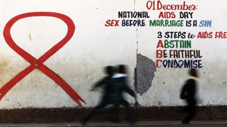Children run past a mural painting of an Aids ribbon at a school in Khutsong Township, west of Johannesburg