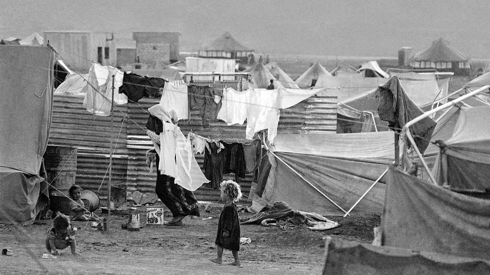 Little children play amid lines of laundry drying out at Baqaa Camp in Jordan for Palestinian refugees of the 1967 war - some were refugees from 1948 [The Associated Press]