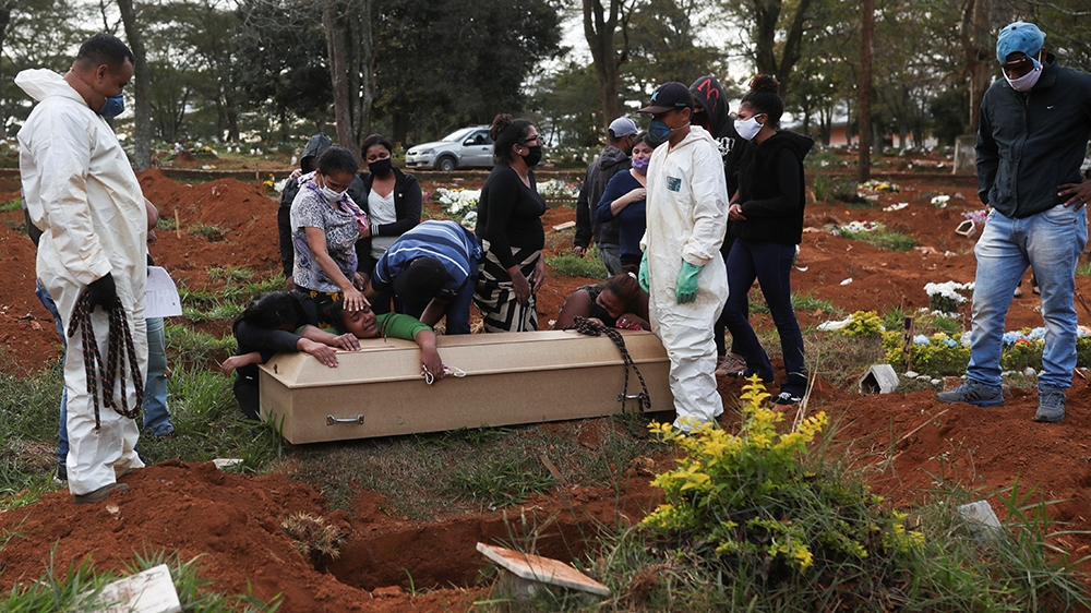 Relatives react during the burial of 64-year-old Raimunda Conceicao Souza, who died from the coronavirus disease (COVID-19), at Vila Formosa cemetery, Brazil's biggest cemetery, in Sao Paulo, Brazil