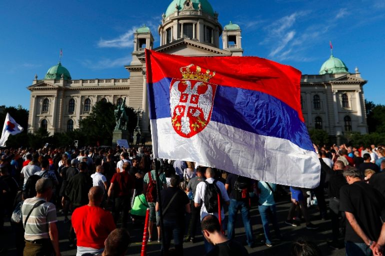 People attend a protest against President Aleksandar Vucic and his government in front of the Serbian parliament building, in Belgrade, Serbia, Saturday, June 20, 2020.