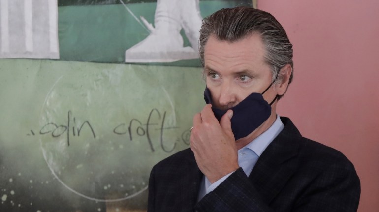 California Governorn Gavin Newsom adjusts his mask while speaking to reporters at Miss Ollie''s restaurant amid the coronavirus pandemic in Oakland, California, USA, 09 June 2020. EPA-EFE/JEFF CHIU / A