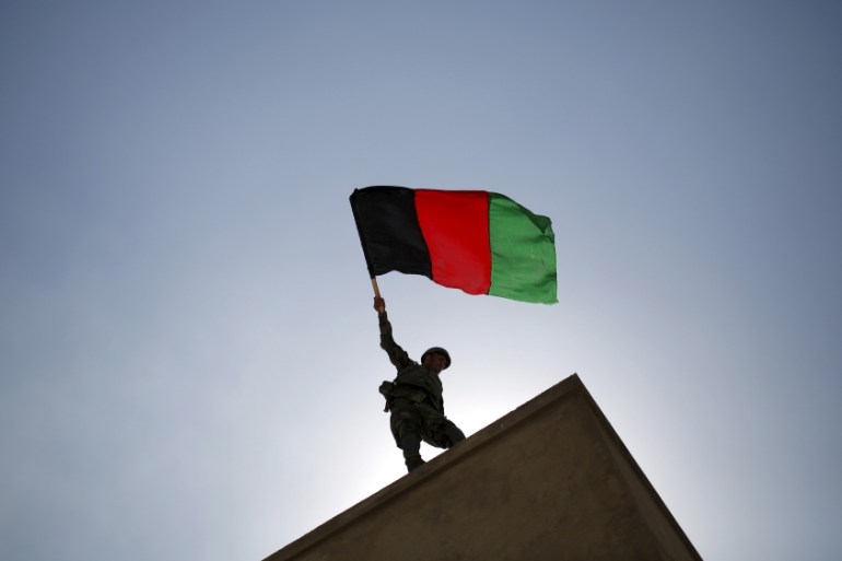 An ANA officer holds an Afghanistan flag during a training exercise at the Kabul Military Training Centre