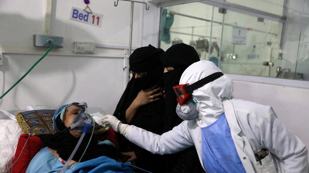 Women watch as a nurse attends to their relative who is being treated at an intensive care unit of a hospital for the coronavirus disease (COVID-19) in Sanaa