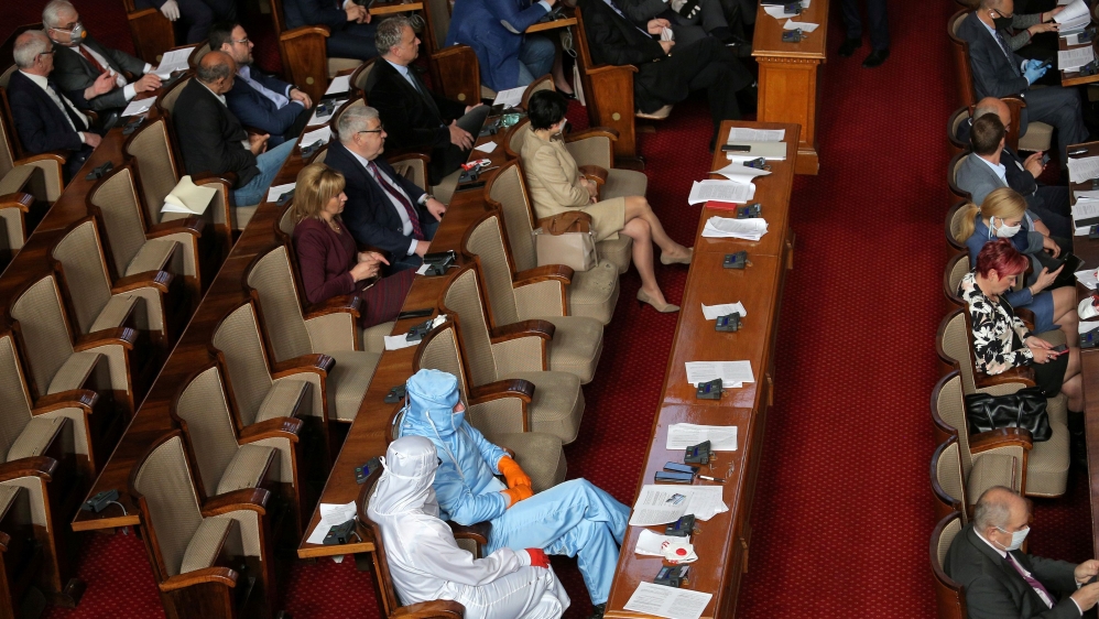 Leader of Bulgarian party Volya, Mareshki, and a deputy from his party wear protective suits during debates in the parliament in Sofia