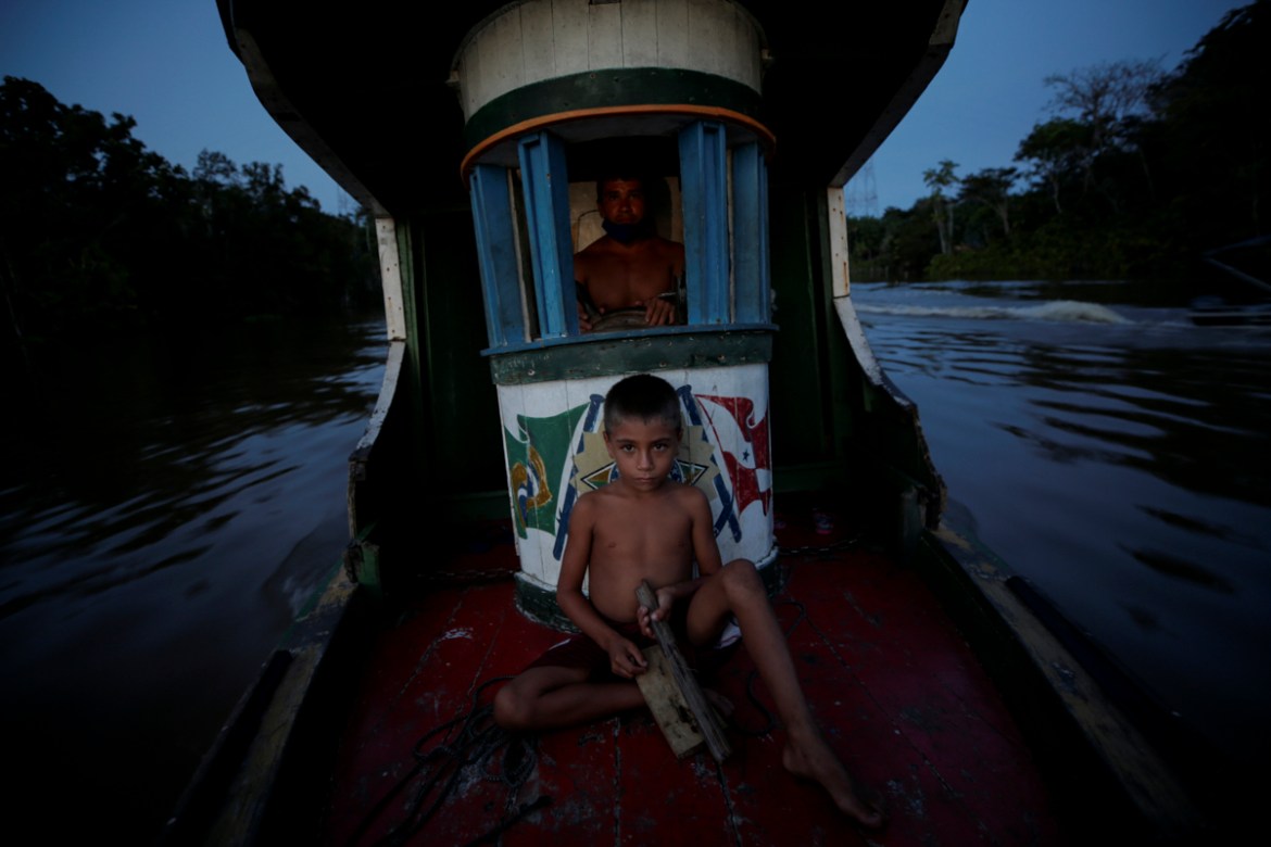 Amadeu Amaral, 7, sails with his father along the Parauau River, during the coronavirus disease (COVID-19) outbreak, in the municipality of Breves, Marajo island, Para state, Brazil, June 7, 2020. REU