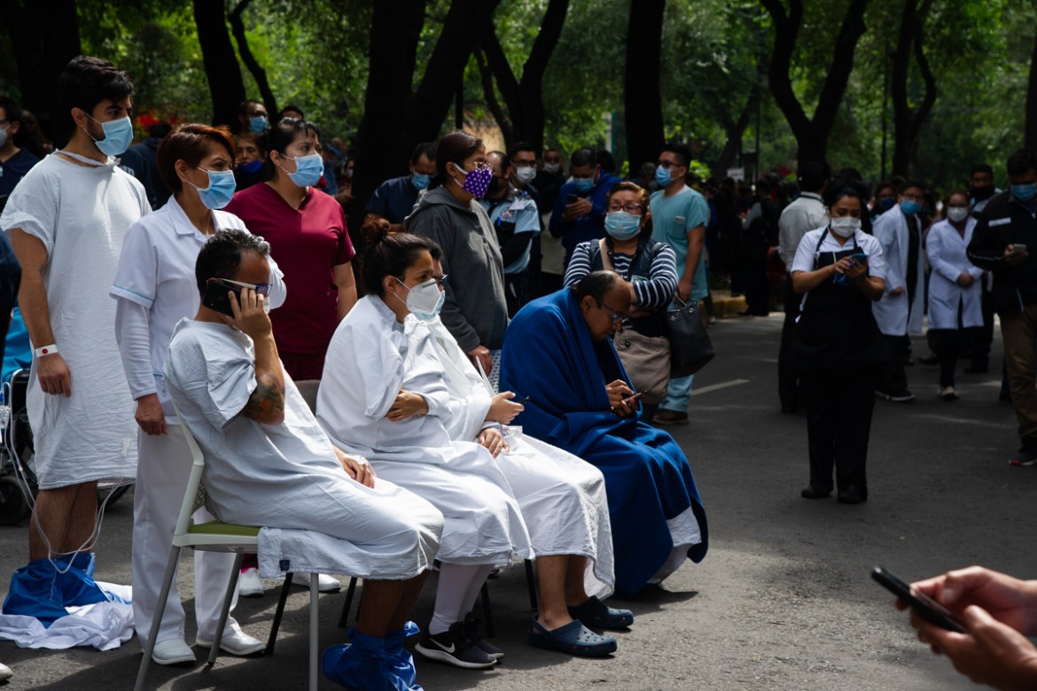 People remain outside the Durango clinic in Mexico City during a quake on June 23, 2020 amid the COVID-19 novel coronavirus pandemic. - A 7.1 magnitude quake was registered Tuesday in the south of Mex