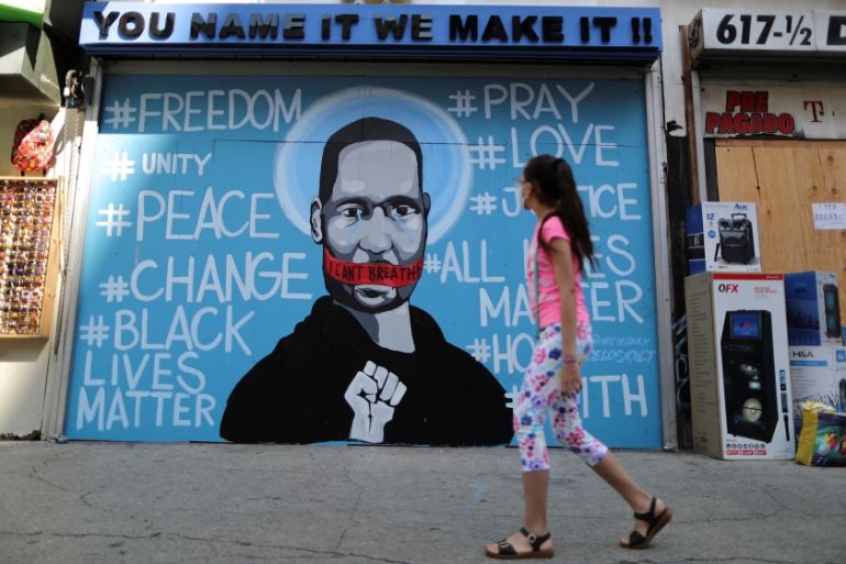 A girl walks past a mural commemorating George Floyd, in downtown Los Angeles, California, U.S. June 4, 2020. REUTERS/Lucy Nicholson
