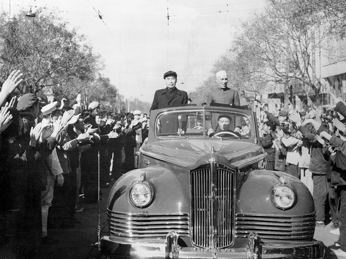 (Original Caption) Prime Minister Jawaharlal Nehru of India is shown, (R), being cheered by crowds that lined the route from the airfield where he landed to the city of Peiping, the capitol of Red Chi