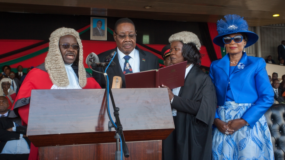Malawi's President elect Arthur Peter Mutharika is sworn in for his second term by Chief Justice Andrew Nyirenda (L) and Registrar of the high Court and Supreme court of appeal Agnes Patemba (R) at K
