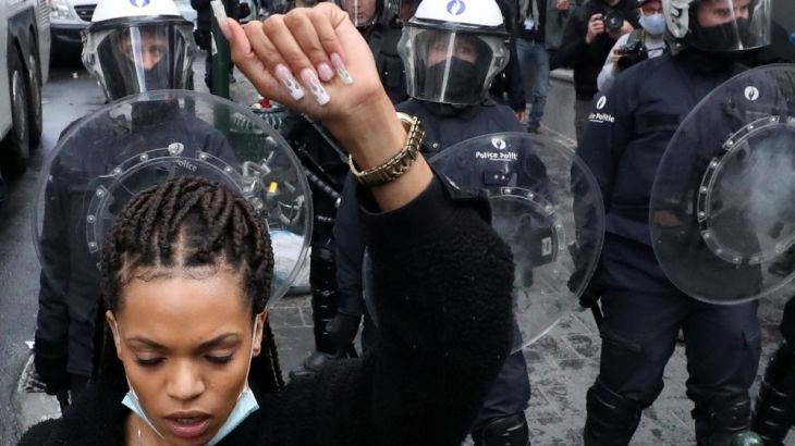 A demonstrator gestures in front of police officers during a protest organised by Black Lives Matter Belgium, against racial inequality in the aftermath of the death in Min