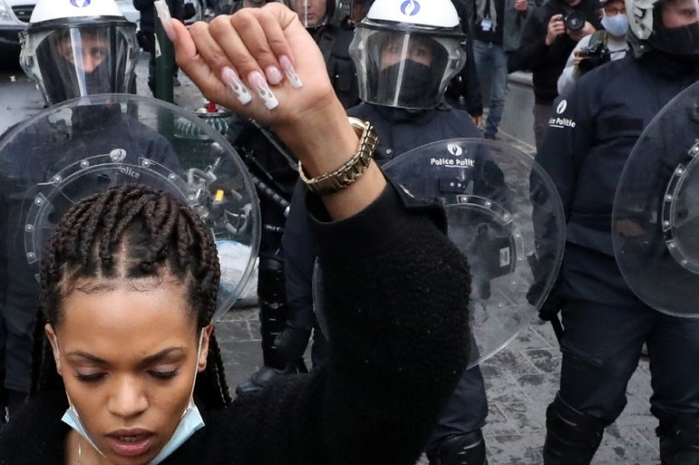 A demonstrator gestures in front of police officers during a protest organised by Black Lives Matter Belgium, against racial inequality in the aftermath of the death in Min