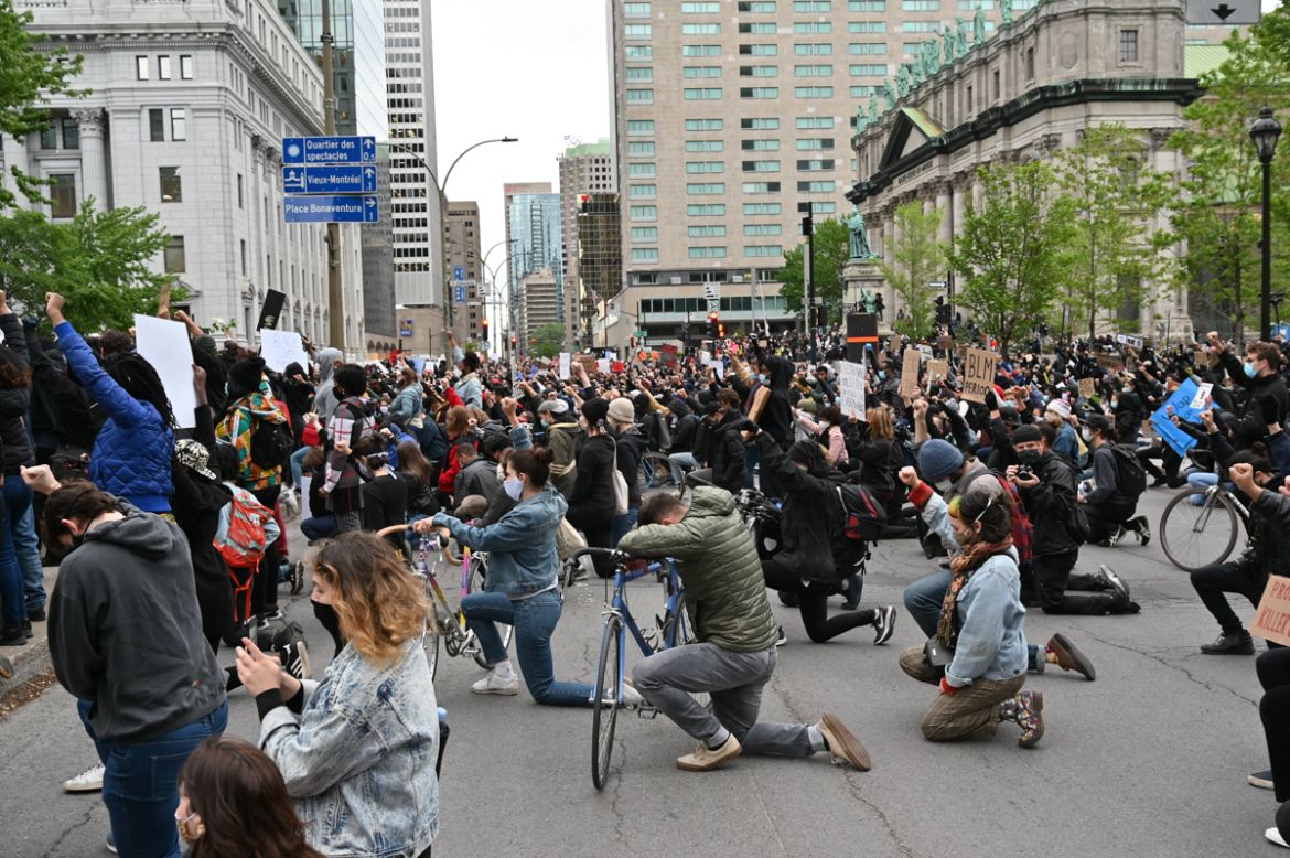The crowd kneel as it observes a minute of silence in memory of George Floyd, killed at the hands of Minnieapolis Police, during a rally on Montreal''s Place du Canada on May 31, 2020. - Several thousa