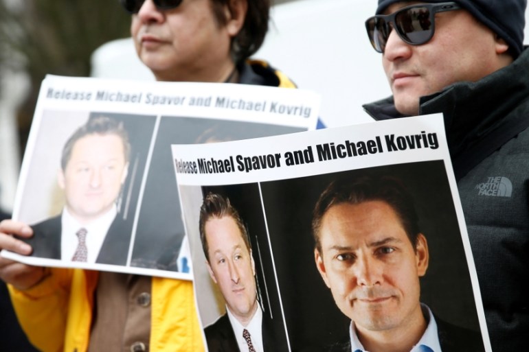 eople hold signs calling for China to release Canadian detainees Spavor and Kovrig