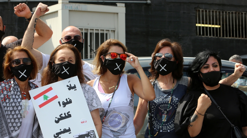 Demonstrators wearing protective masks stand together during a protest against the government's performance and worsening economic conditions near the presidential palace in Baabda, Lebanon June 25, 2