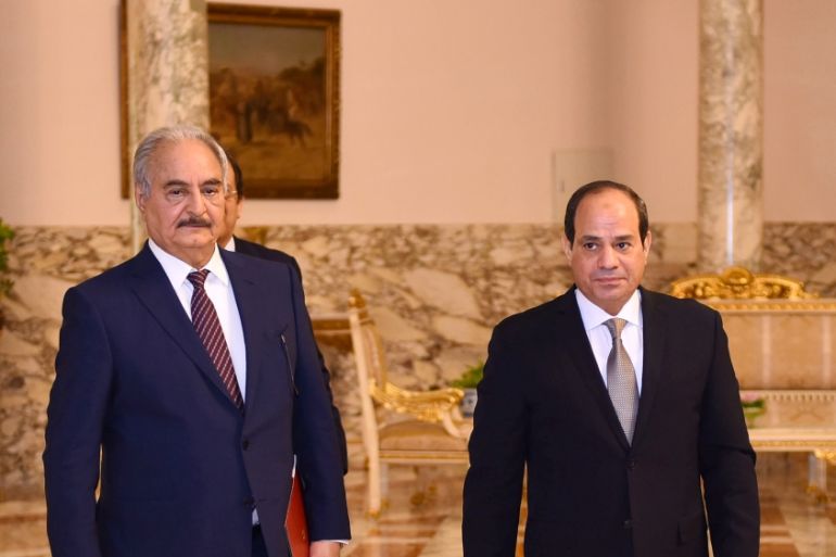 Libyan military commander Khalifa Haftar walks with Egyptian President Abdel Fattah al-Sisi at the Presidential Palace in Cairo