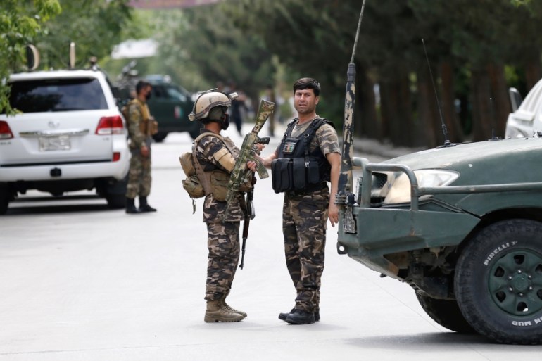 Afghan security forces stand guard near the site of an attack in Kabul, Afghanistan