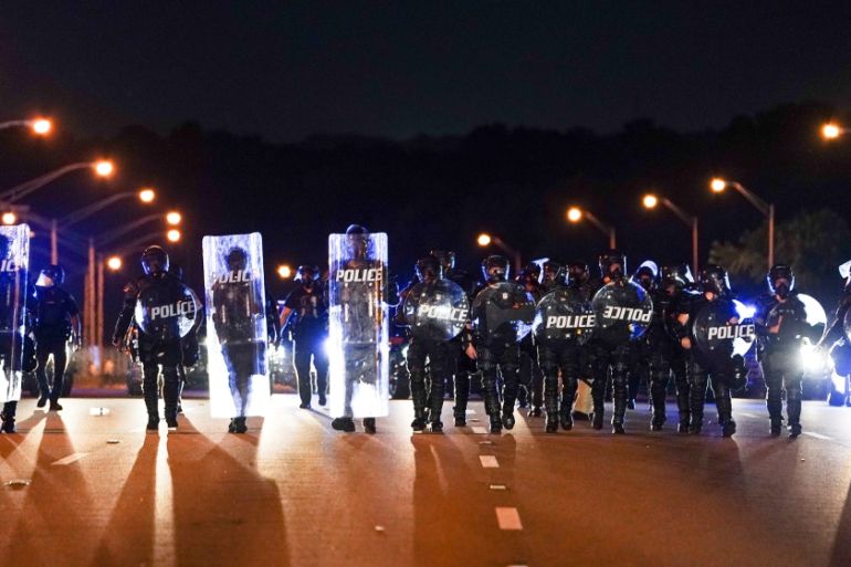Police with riot shields advance to detain protesters for blocking traffic on a freeway during a rally against racial inequality and the police shooting death of Rayshard Brooks, in Atlanta, Georgia,