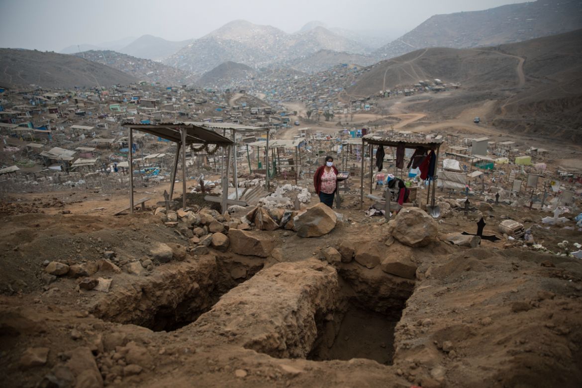 A candy seller waits for customers near empty tombs at the Nueva Esperanza cemetery on the outskirts of Lima, Peru, Thursday, May 28, 2020. (AP Photo/Rodrigo Abd)