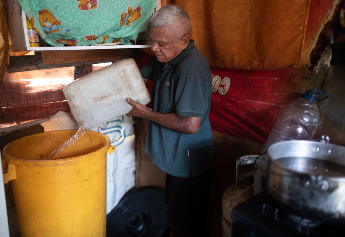 Jesus Marcanao, 65, fills a container with water he tapped from a street faucet, in his home in Caracas, Venezuela, Saturday, June 13, 2020. Amid water shortages during the COVID-19 pandemic, the gove