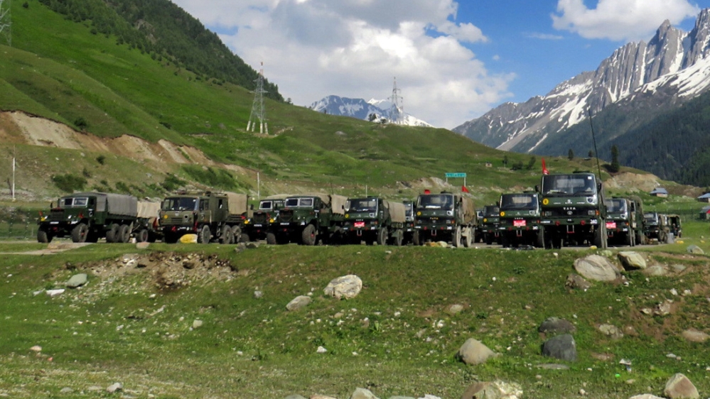 Indian army soldiers walk past their parked trucks at a makeshift transit camp before heading to Ladakh, near Baltal, southeast of Srinagar, June 16, 2020. REUTERS/Stringer NO RESALES. NO ARCHIVES. TP
