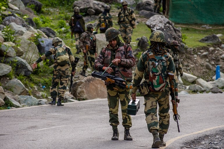 GAGANGIR, KASHMIR, INDIA - JUNE 19: Indian Border Security Force (BSF) soldiers patrol a highway as Indian army convoy passes through on a highway leading towards Leh, bordering China, on June 19, 20