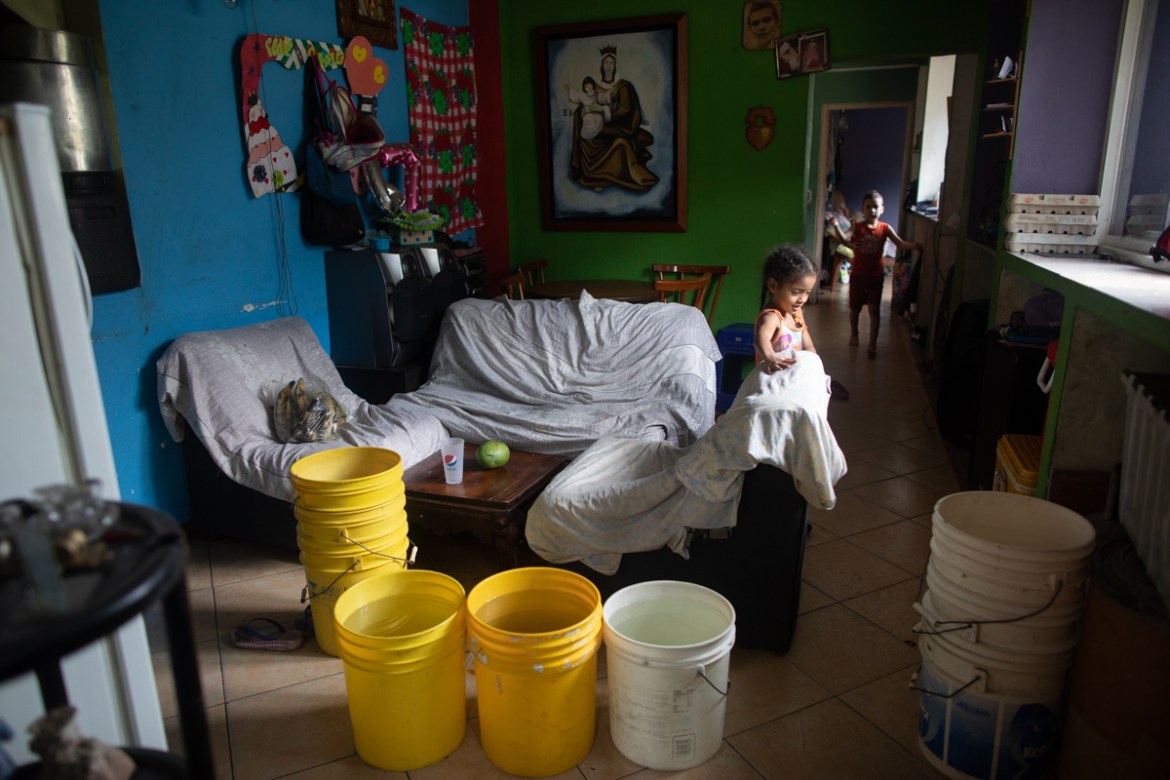 Buckets, some of them filled with water provided by a government tanker truck, stand in the living room of a house in the Petare neighborhood of Caracas, Venezuela, Monday, June 15, 2020. Water shorta