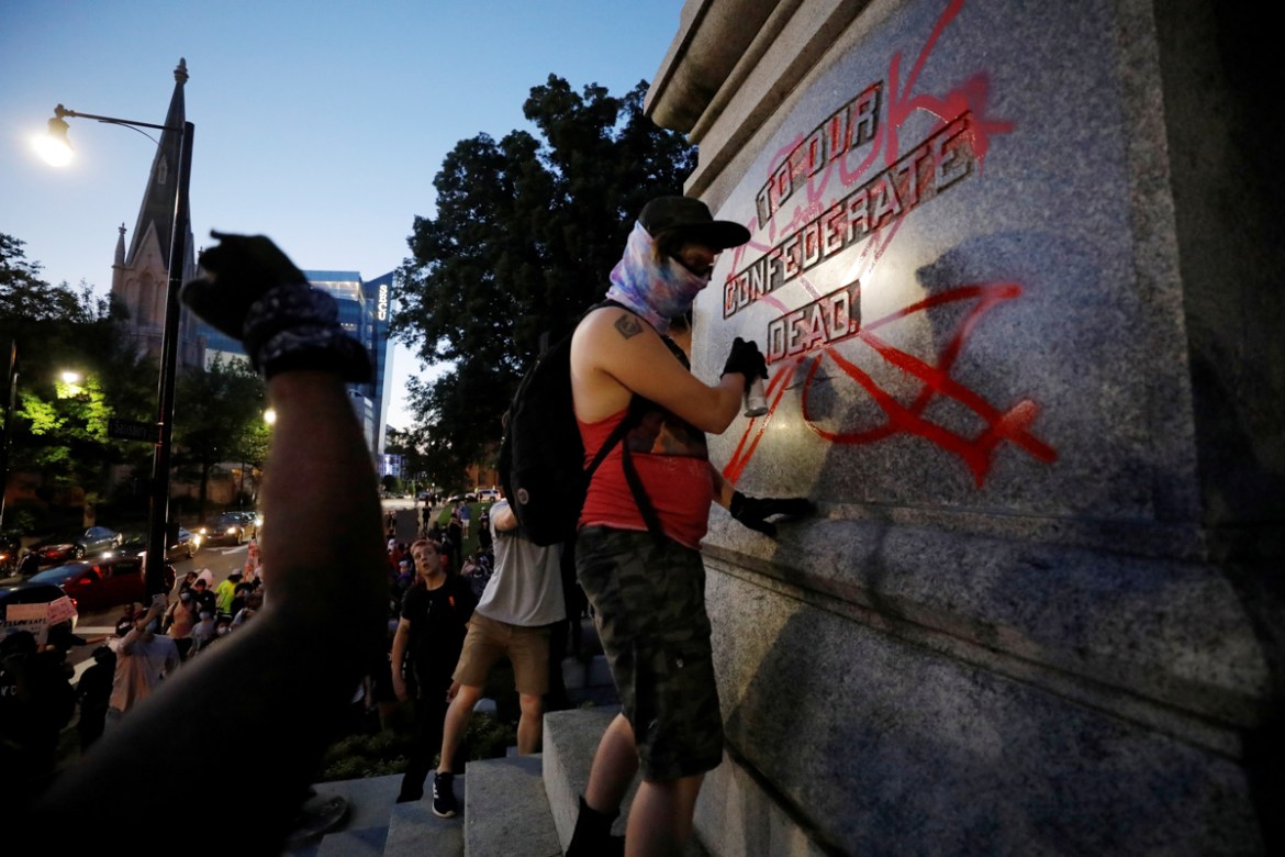 A protester defaces a Confederate monument during nationwide unrest following the death in Minneapolis police custody of George Floyd, in Raleigh, North Carolina, U.S. May 31, 2020. Picture taken May