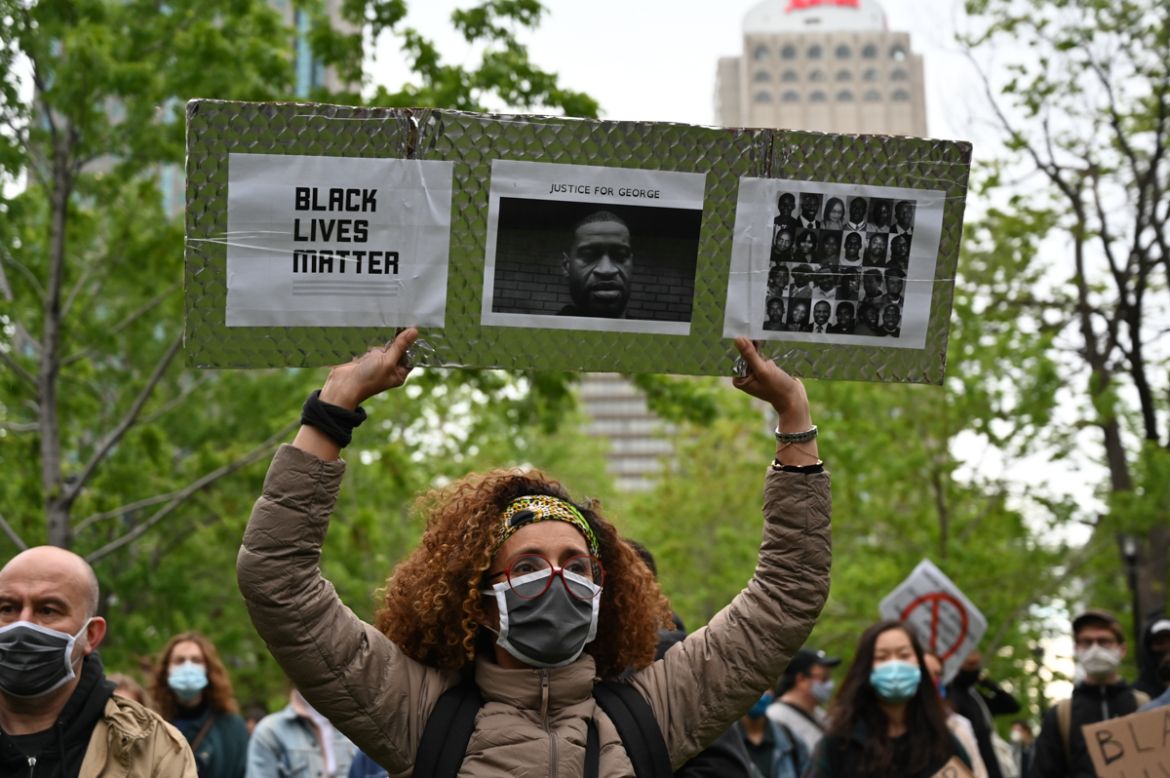 A woman is holding a Black Lives Matter placard asking for Justice for George and other victims of racism and police brutalities on Montreal''s Place du Canada on May 31, 2020. - Several thousands demo