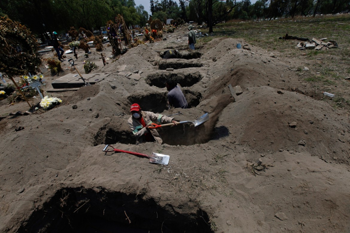 Melvin Sanaurio, front, digs a grave at the San Lorenzo Tezonco Iztapalapa cemetery in Mexico City, Tuesday, June 2, 2020, amid the new coronavirus pandemic. "It takes me more than an hour to dig one