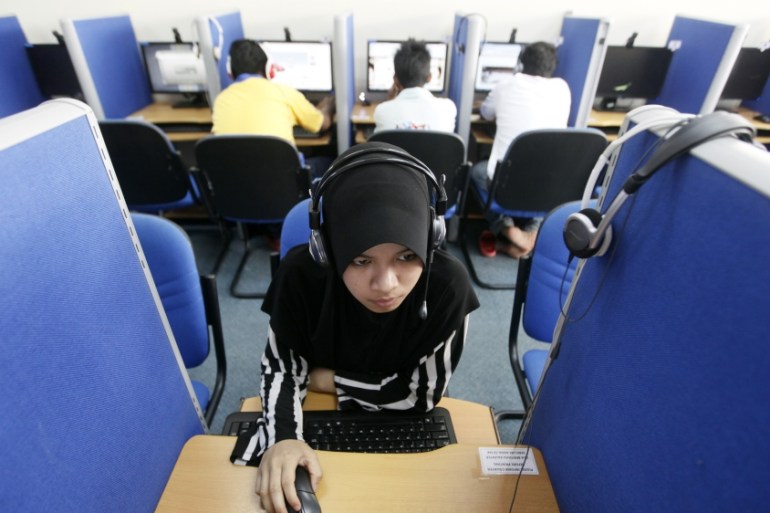 A woman browses the Internet at a cyber cafe in Putrajaya