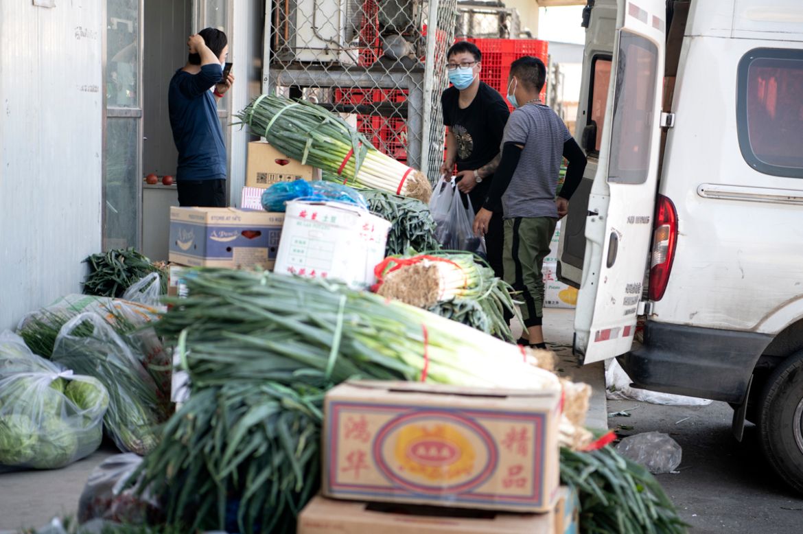 Workers arranges vegetables at the closed Xinfadi Market in Beijing on June 14, 2020. - The domestic COVID-19 coronavirus outbreak in China had been brought largely under control through strict lockdo