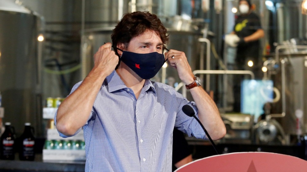 FILE PHOTO: Canada's Prime Minister Justin Trudeau removes his face mask as he visits the Big Rig Brewery, which utilizes the Canada Emergency Wage Subsidy given to businesses affected 
