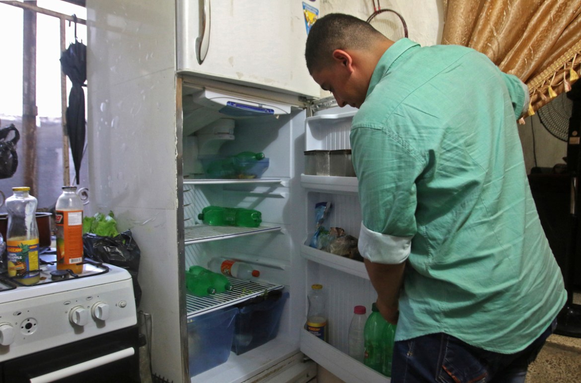 A Lebanese man displays the content of his refrigerator at his apartment in the southern city of Sidon on June 16, 2020. - Lebanon''s economic crisis has led to a collapse of the local currency and pur