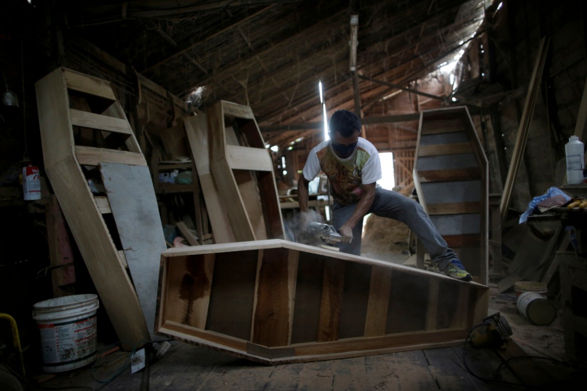 Jorge Silva, 35, an employee who works at Terra Santa Urns Factory, which manufactures coffins, buffs the wood of a coffin, during the coronavirus disease (COVID-19) outbreak, in the municipality of B