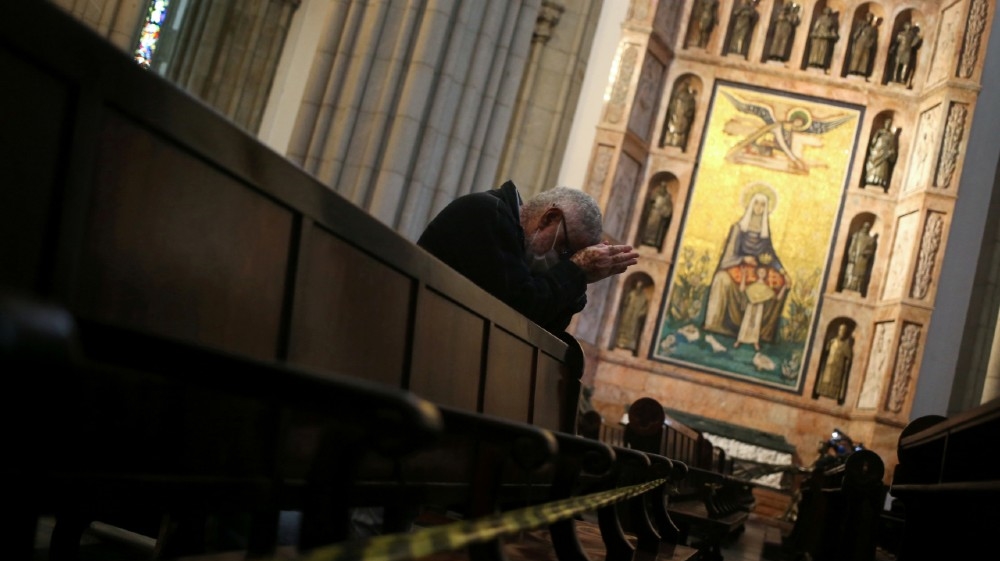 A faithful prays next to blocked sits to keep social distance at Se Cathedral during a mass as the city eases restrictions, amid the coronavirus disease (COVID-19) outbreak,