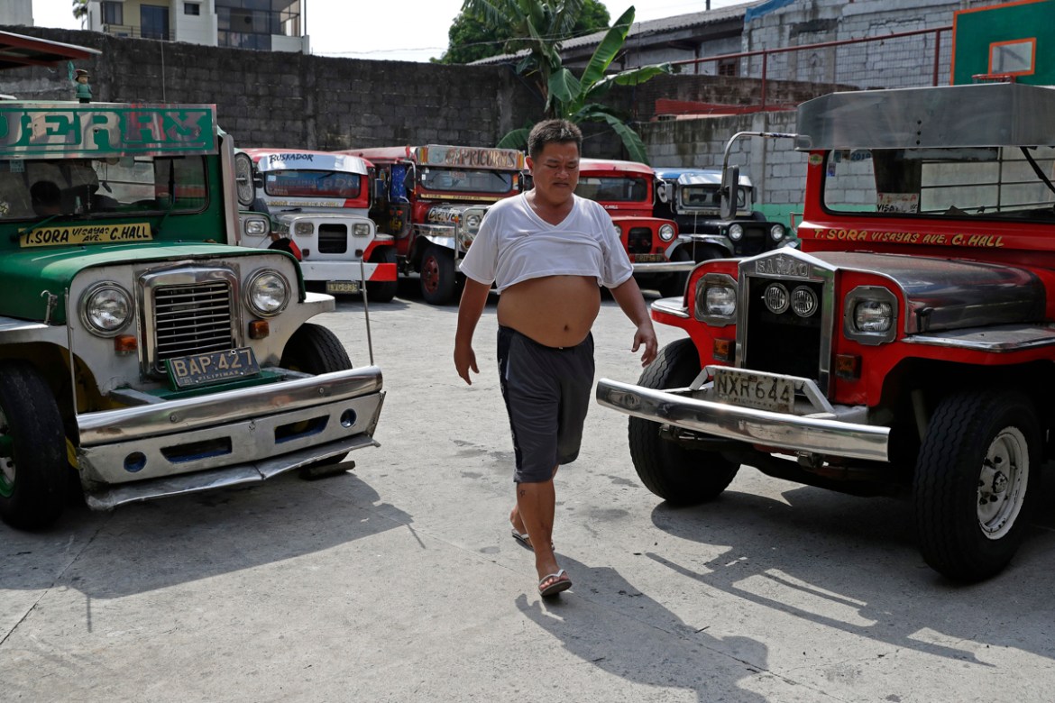 Driver Jude Recio walks past jeepneys parked at the Tandang Sora terminal which have been home for them since a lockdown started three months ago, on Wednesday, June 17, 2020 in Quezon city, Philippin