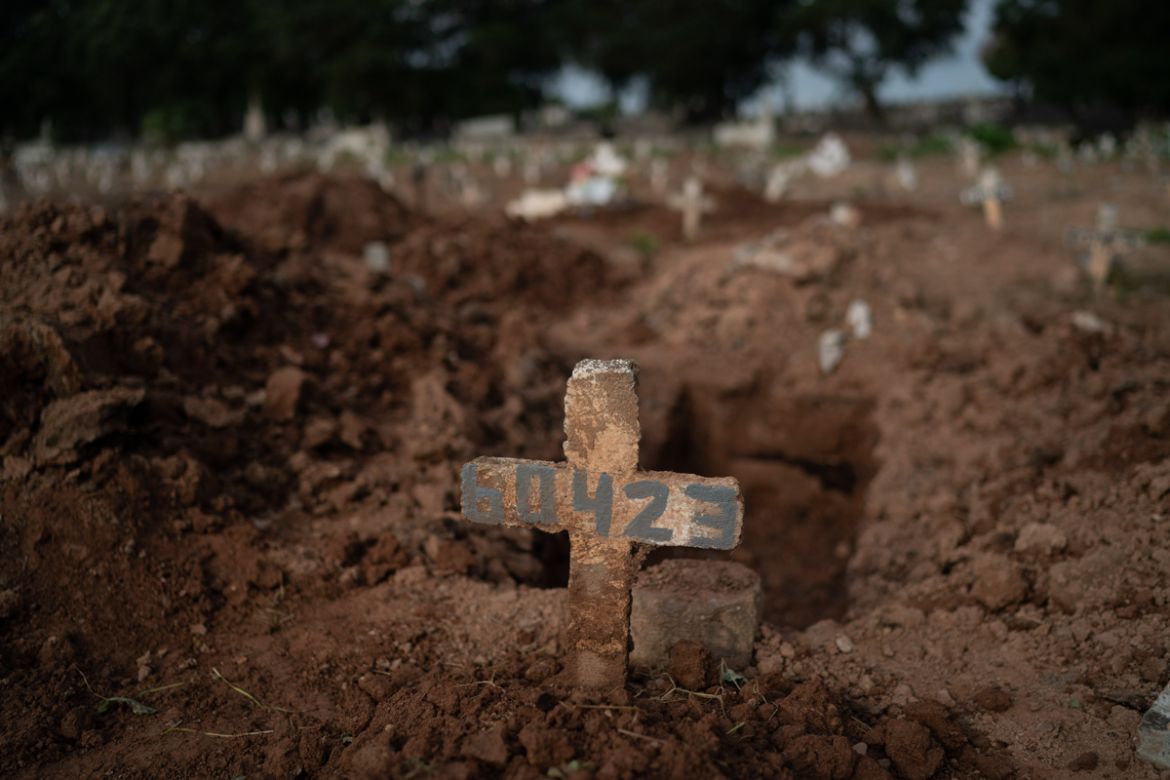 A cross marks the grave of 57-year-old Paulo Jose da Silva, who died from the new coronavirus, in Rio de Janeiro, Brazil, Friday, June 5, 2020. According to Monique dos Santos, her stepfather mocked t